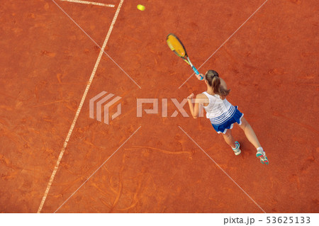 Aerial shot of a female tennis player on a court during match. Young woman playing tennis.High angle 53625133