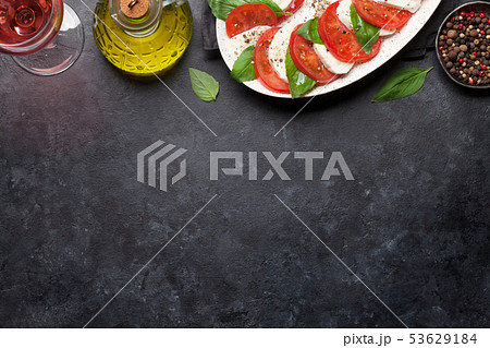 Delicious italian caprese salad and wine glass Delicious italian caprese salad and wine glass 53629184