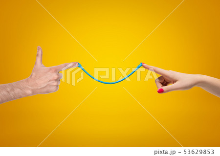 Side crop closeup of woman's and man's hands pointing fingers to each other, connected by thin 53629853