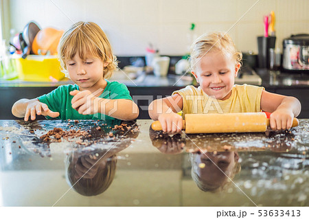 Two children a boy and a girl make cookies from dough Two children a boy and a girl make cookies from dough 53633413