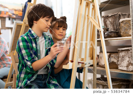 Brother and sister drawing in art school together 53634784