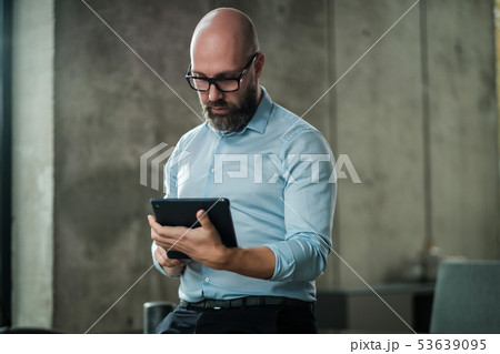 Middle-aged man with a tablet pc in an office Middle-aged man with a tablet pc in an office 53639095