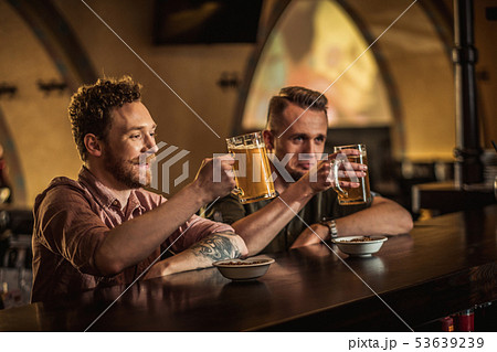 Cheerful friends drinking draft beer in a pub 53639239