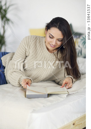 Young happy brunette woman with book 53641537