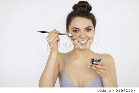 Young woman applies a magnetic mask on her face Young woman applies a magnetic mask on her face 53641557