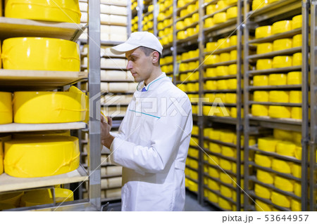 Portrait of inspector standing in production department of dairy factory and take view of redy Portrait of inspector standing in production department of dairy factory and take view of redy 53644957