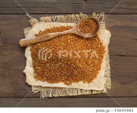 Whole brown millet pile with a spoon Whole brown millet pile with a spoon 53645981