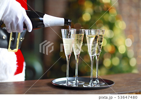 Santa Claus holding champagne glasses on the tray Santa Claus holding champagne glasses on the tray 53647480