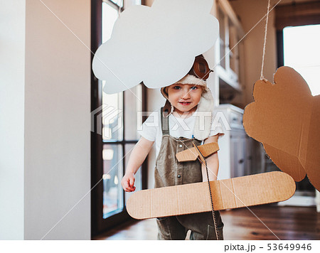 A toddler boy with carton plane playing indoors at home, flying concept. 53649946