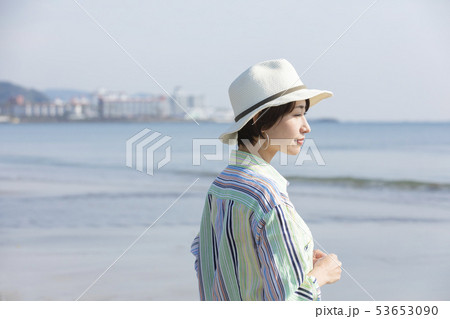 女性　海　日差し 53653090