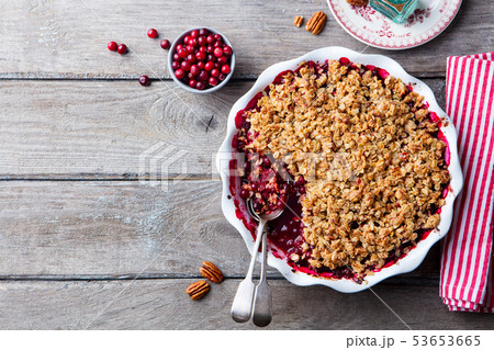 Cranberry crumble, crisp in a baking dish. Wooden background. Top view. Copy space. Cranberry crumble, crisp in a baking dish. Wooden background. Top view. Copy space. 53653665