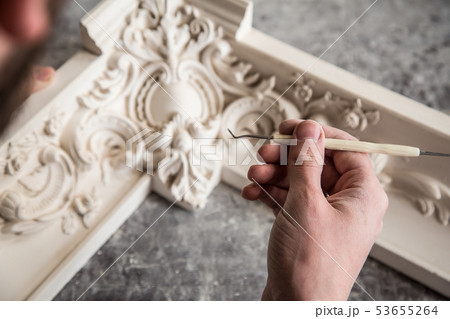 The sculptor creates a bas-relief. Plaster workshop. Close up. Selective focus. 53655264