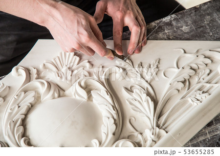 Hands of the sculptor with the tool. The sculptor works in the Studio. Creation of a decorative Hands of the sculptor with the tool. The sculptor works in the Studio. Creation of a decorative 53655285