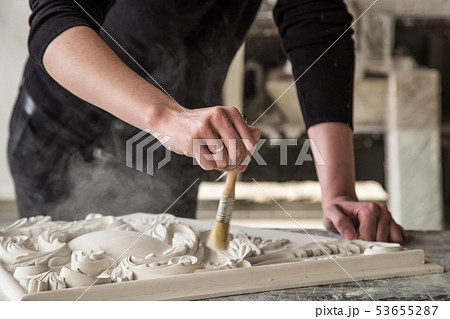 Hands of the sculptor with the tool. The sculptor works in the Studio. Creation of a decorative 53655287