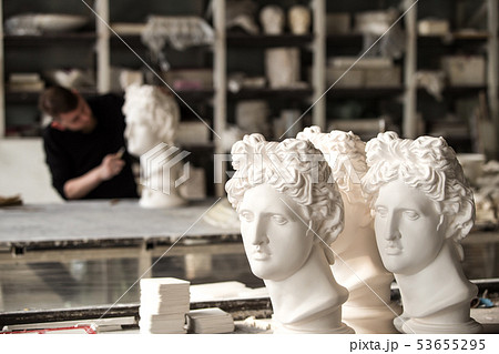 Gypsum sculptures. The heads of the gypsum apollo in the workshop. Gypsum sculptures. The heads of the gypsum apollo in the workshop. 53655295