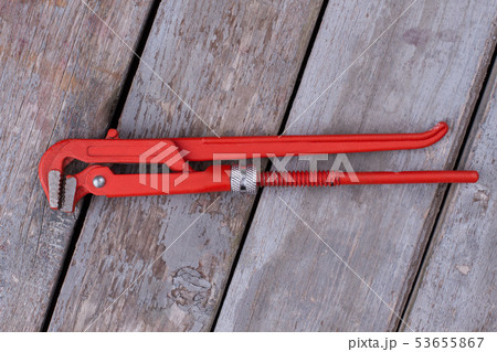 Adjustable wrench on wooden boards background. Adjustable wrench on wooden boards background. 53655867