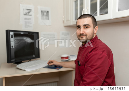 A doctor radiologist at the workplace looks at A doctor radiologist at the workplace looks at 53655935