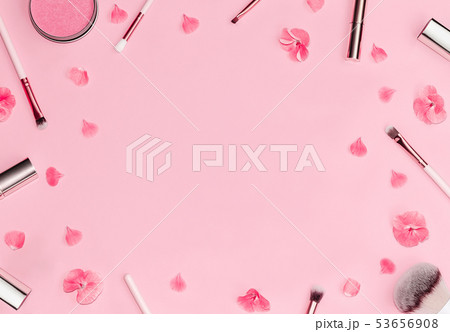 Flat lay composition with decorative makeup products and pink flowers on pastel pink background. 53656908