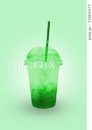 Green juice with ice in a plastic glass. Green juice with ice in a plastic glass. 53665477