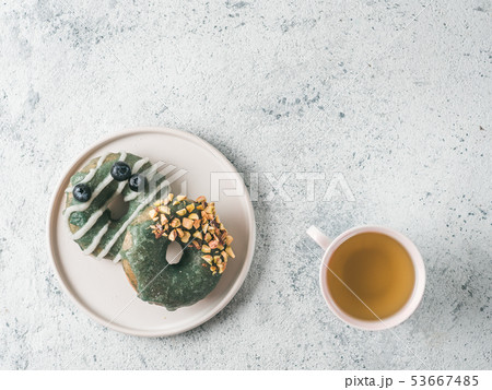 Vegan donuts topped spirulina glaze and tea Vegan donuts topped spirulina glaze and tea 53667485