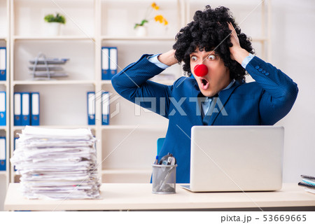 Young clown businessman working in the office Young clown businessman working in the office 53669665