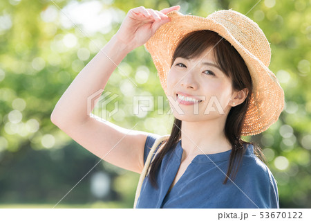 麦わら帽子をかぶった若い女性 新緑 夏 リゾートの写真素材