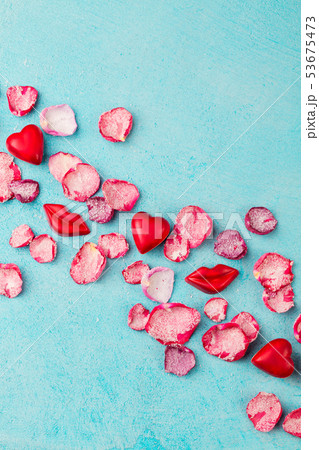 Chocolate heart and lips shaped candies with rose candied sugared petals. Blue background. Top view. 53675473