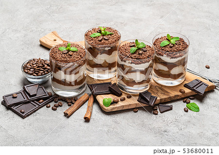 Classic tiramisu dessert in a glass on dark concrete background Classic tiramisu dessert in a glass on dark concrete background 53680011