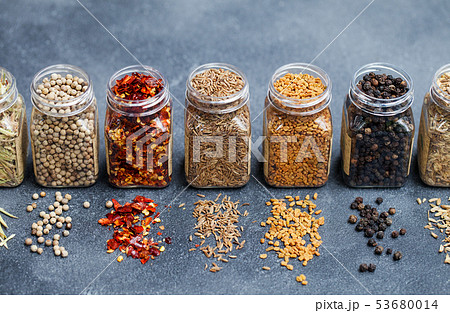 Assortments of spices in jars on grey stone background. Assortments of spices in jars on grey stone background. 53680014