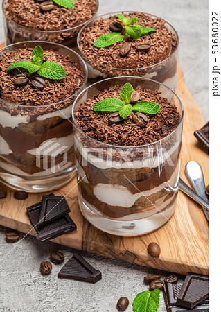 Classic tiramisu dessert in a glass on dark concrete background Classic tiramisu dessert in a glass on dark concrete background 53680022