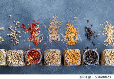 Assortments of spices in jars on grey stone background. Top view. Copy space. Assortments of spices in jars on grey stone background. Top view. Copy space. 53680023