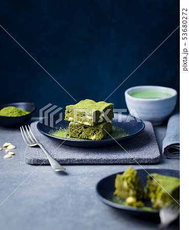 Matcha green tea cake, bars, brownie with white chocolate on a plate. Grey background. Copy space. 53680272