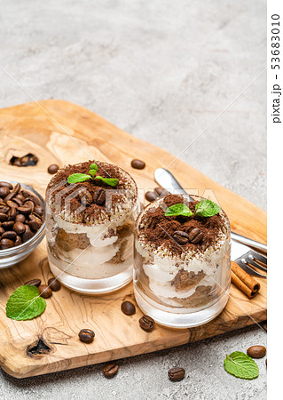 Classic tiramisu dessert in a glass on dark concrete background 53683010