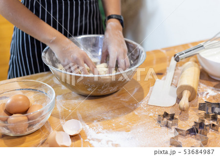 Girls mixing dough, making cookies in the kitchen Girls mixing dough, making cookies in the kitchen 53684987