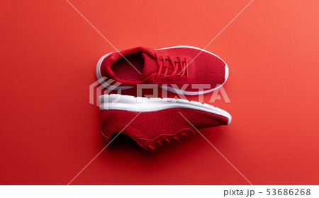 A studio shot of pair of running shoes on red background. Flat lay. 53686268