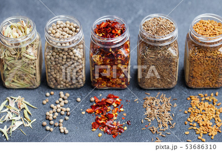 Assortments of spices in jars on grey stone background. Assortments of spices in jars on grey stone background. 53686310