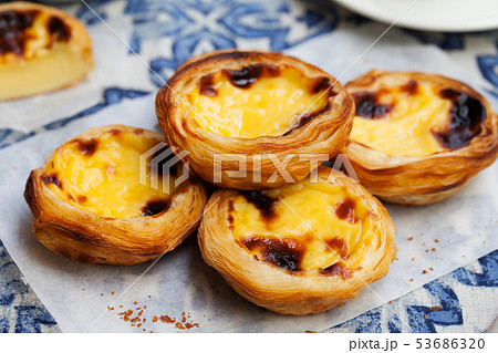 Egg tart, traditional Portuguese dessert, pastel de nata on a plate. Blue textile background. 53686320
