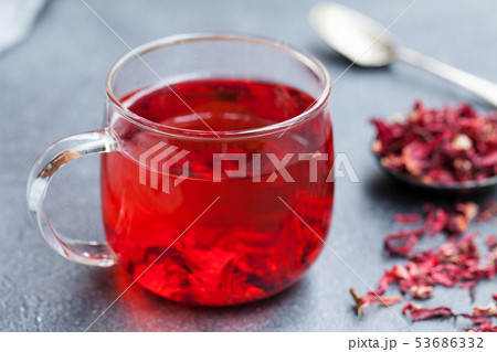 Hibiscus tea in glass cup. Grey background. Close up. Hibiscus tea in glass cup. Grey background. Close up. 53686332