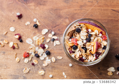 Granola, muesli in glass jar. Healthy breakfast. Organic oats with berries and nuts. Top view. 53686342
