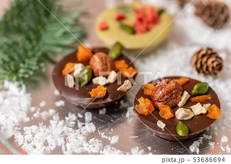 Christmas theme. Handmade chocolates candy. Mini chocolate dessert covered with nuts and dried 53686694