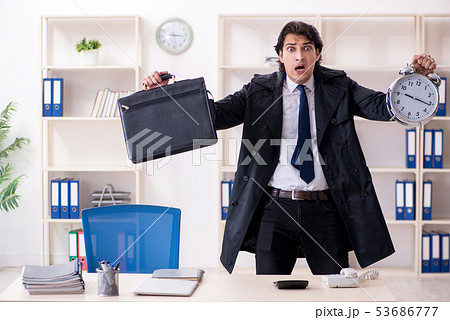 Young male employee in the office in time management concept  53686777