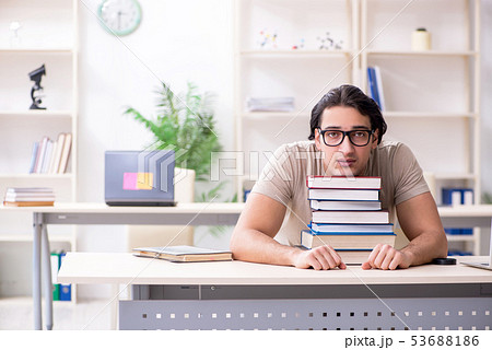 Young male student preparing for exams at home  53688186