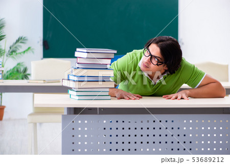 Young male student in front of green board  53689212