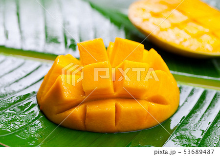 Fresh mango on green palm leaf. Close up. 53689487