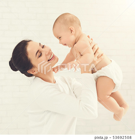 Young mom holding her happy baby in air Young mom holding her happy baby in air 53692508