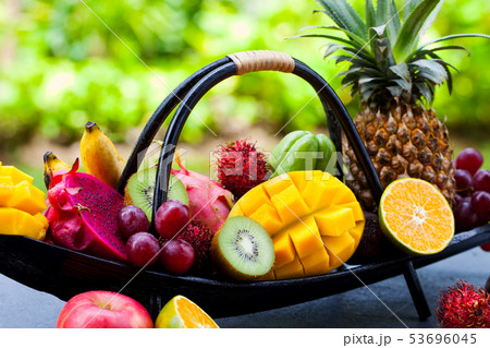 Tropical fruits assortment in wooden boat. Outdoor tropical background. Close up. 53696045
