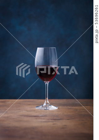 Glass of red wine on wooden table. Blue background. Copy space. 53696261
