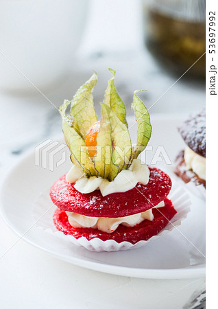 One red whoopie pie on plate. 53697992