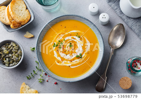 Pumpkin and carrot soup with cream on grey stone background. Top view. 53698779