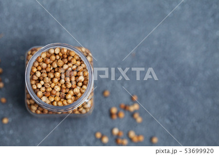Coriander seeds in a jar on grey stone background. Top view. Copy space. Coriander seeds in a jar on grey stone background. Top view. Copy space. 53699920